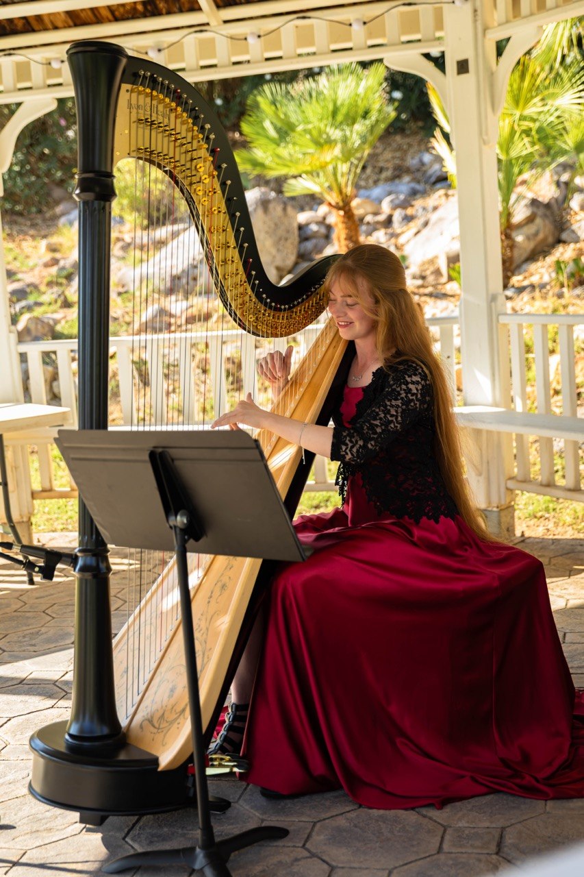 Jennifer playing harp at outdoor event